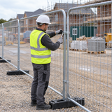Worker fitting a clip between two Eco Heras fence panels